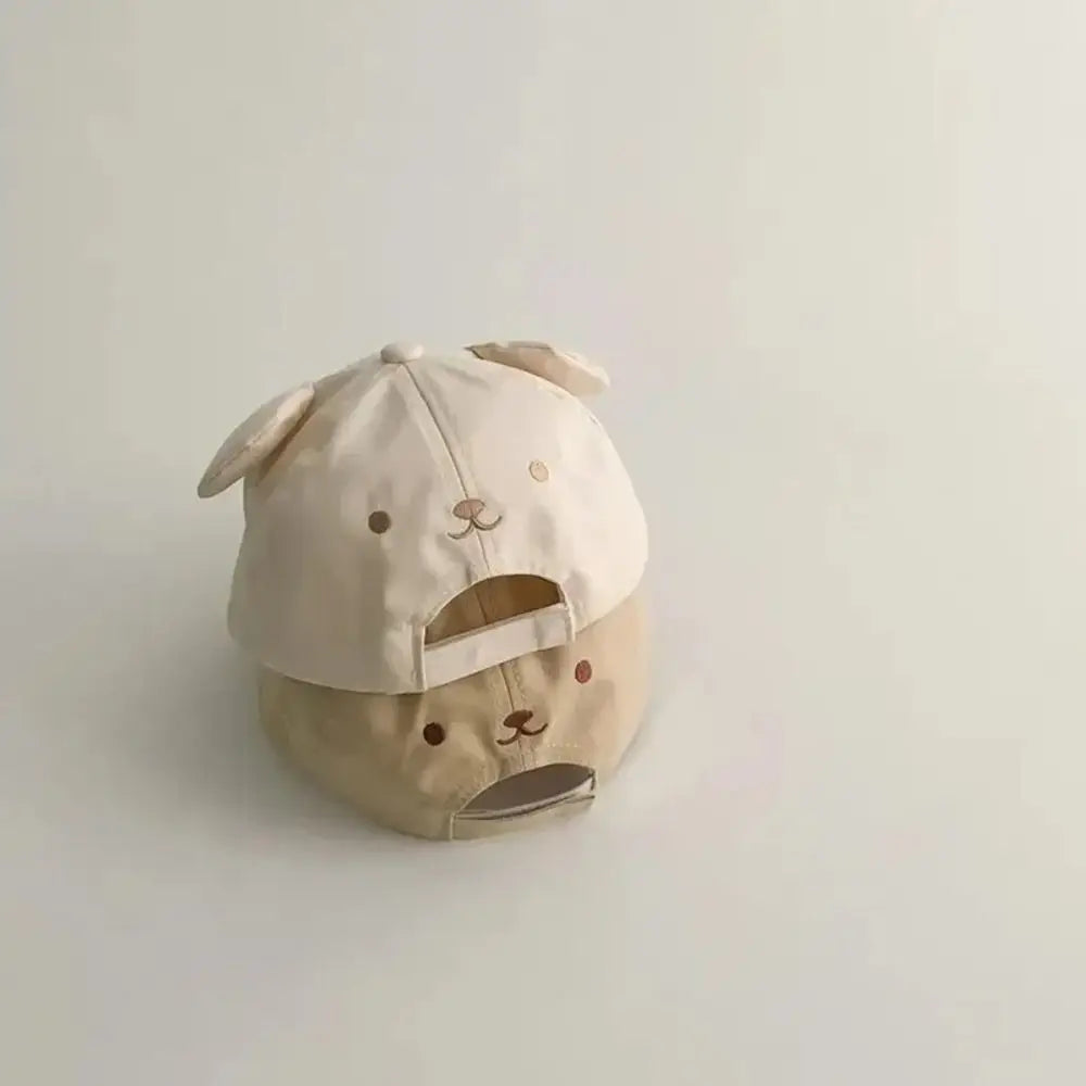 Beige Kawaii cap with dog ears and face design on a light gray background
