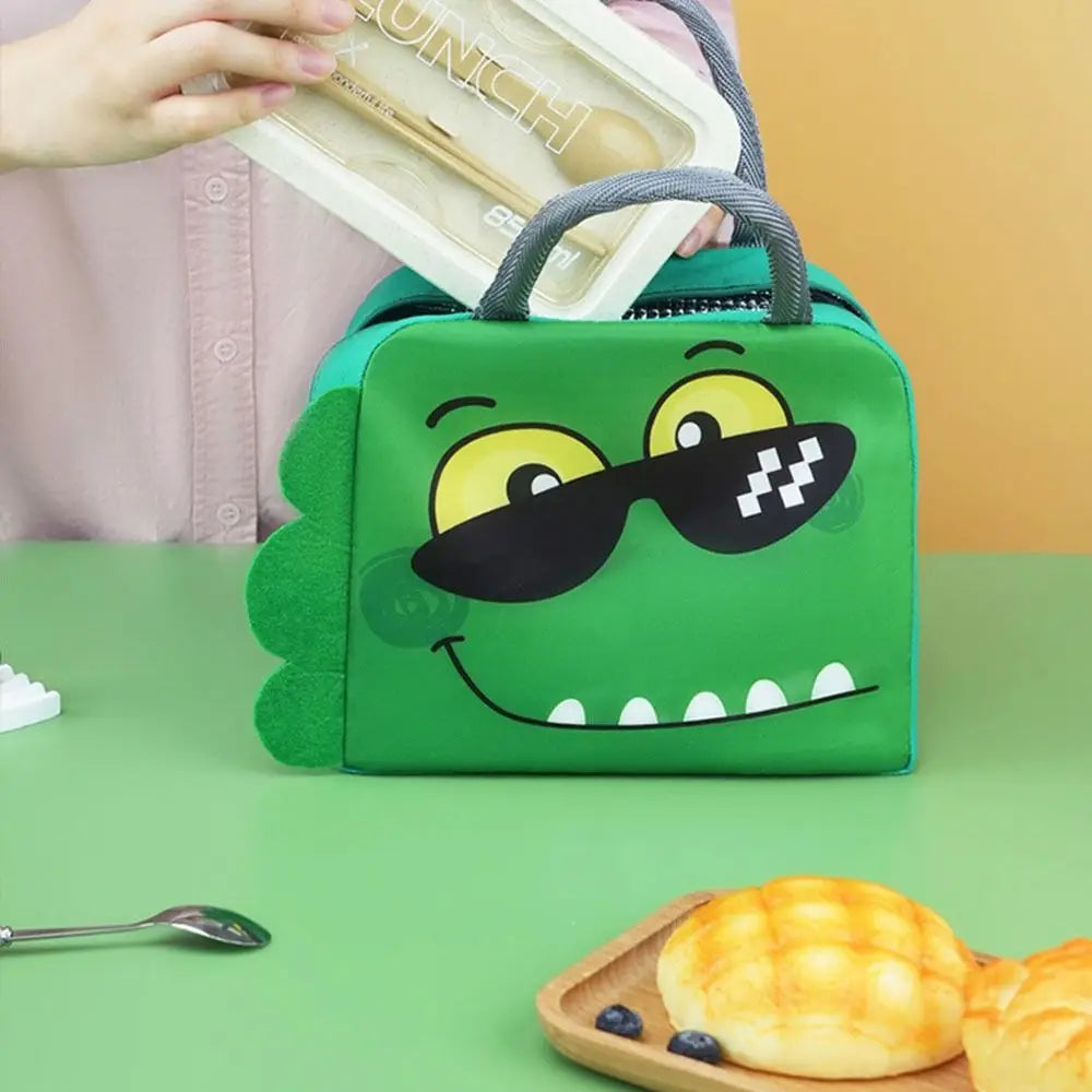 Green cartoon crocodile kawaii lunch bag with a face on a green surface