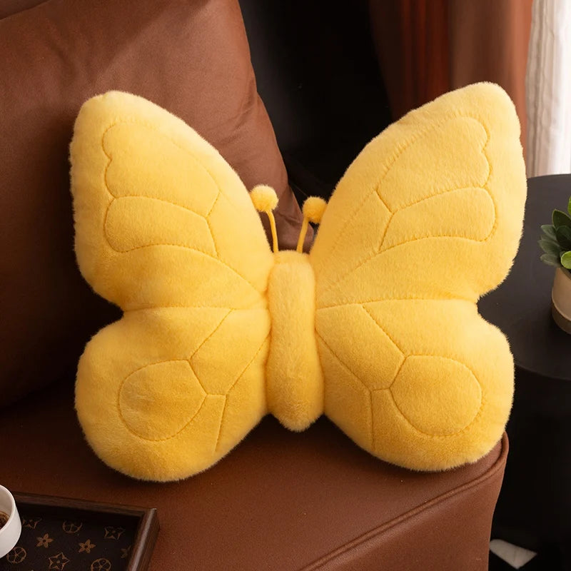 Yellow butterfly-shaped kawaii plush toy on a brown surface