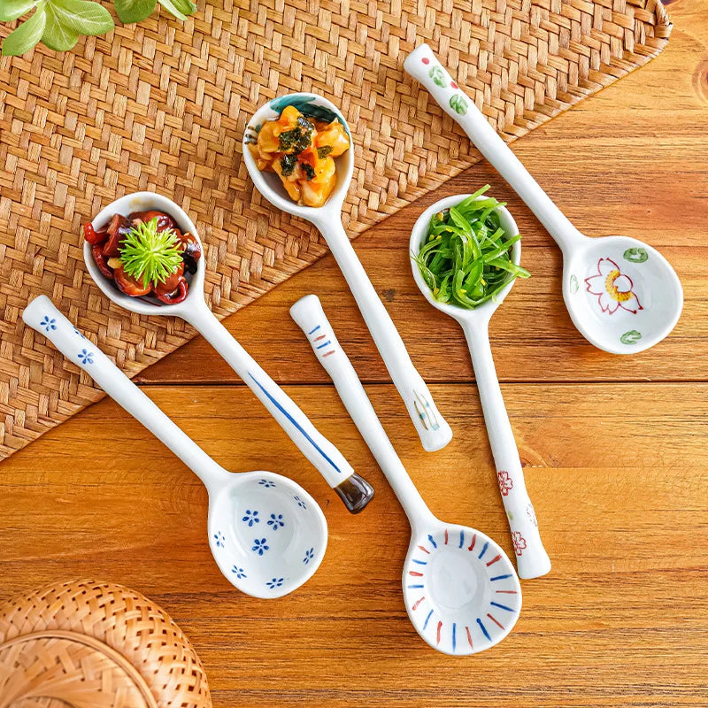 A set of white ceramic kawaii spoons on a wooden surface