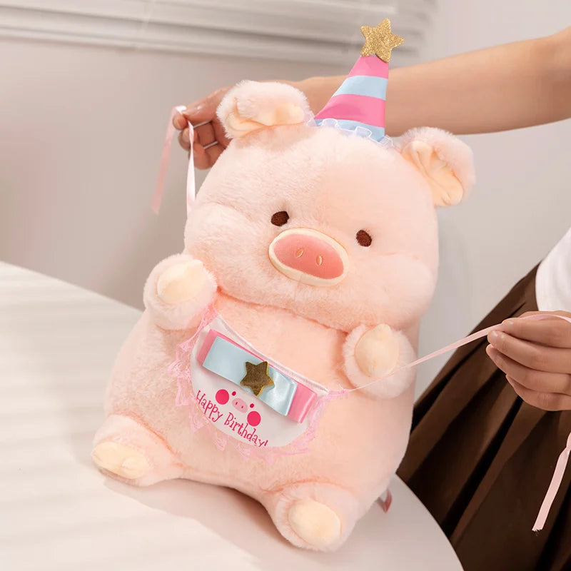 Pink kawaii plush toy with a birthday hat held by a person against a neutral background