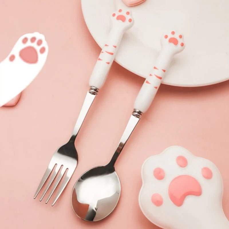 Cute cat paw-shaped kawaii utensils set on a pink background