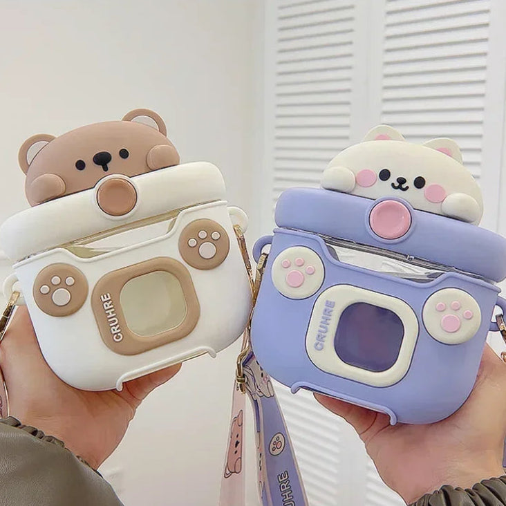 Two cute camera-shaped kawaii water bottles with bear and cat designs held by hands.