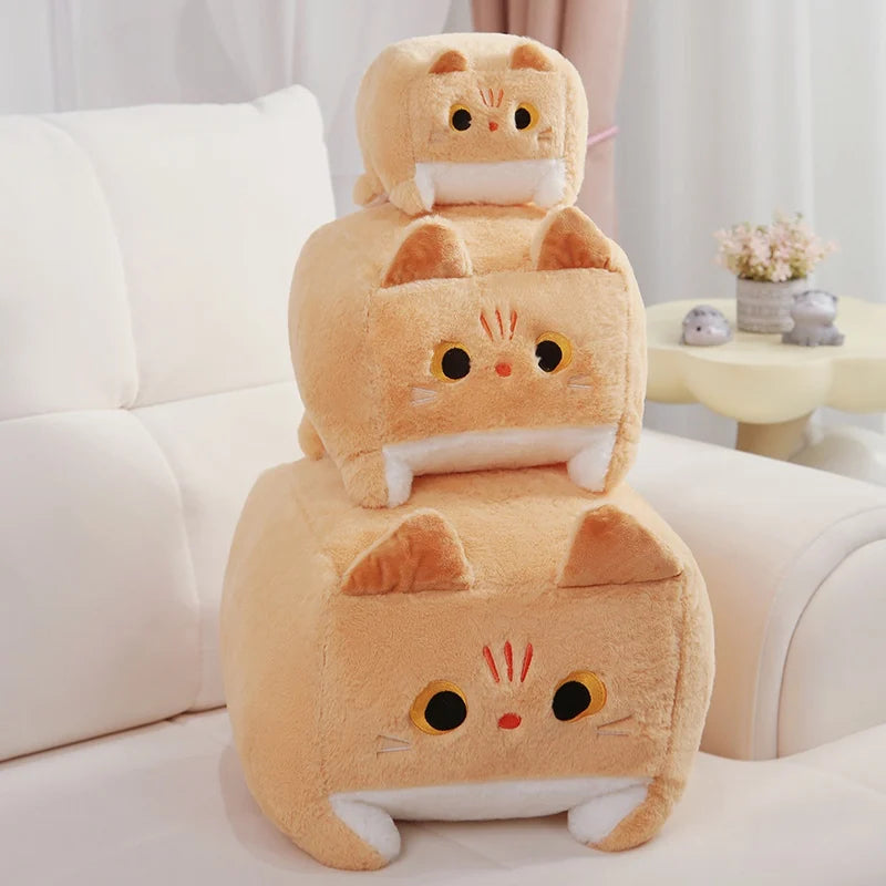 Stack of cat-shaped kawaii plush toys on a white couch