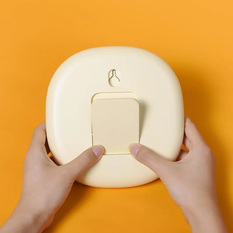 Round beige kawaii clock with a rectangular slot on an orange background