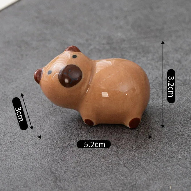 Small brown kawaii animal figurine with measurements on a gray surface