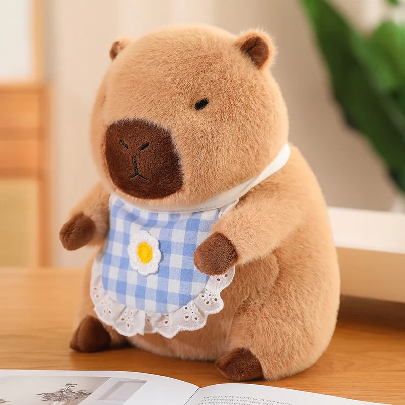Kawaii plush toy bear wearing a checkered bib on a wooden surface