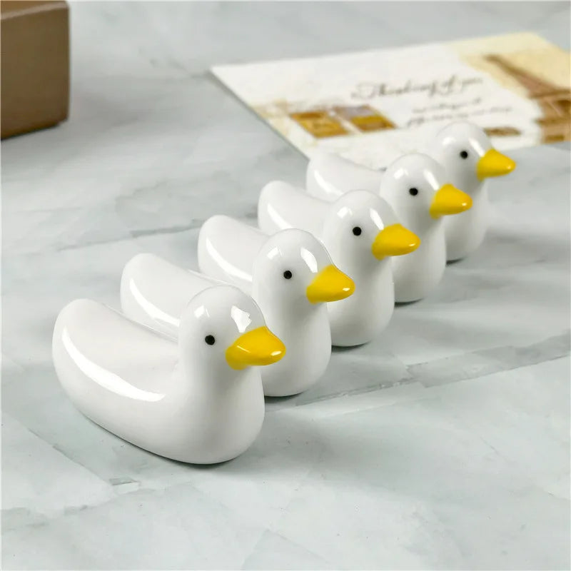 A group of duck shaped kawaii chopstick holders sitting on a table