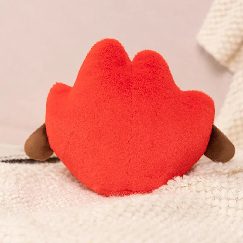 Red kawaii plush toy shaped like a paw on a soft surface