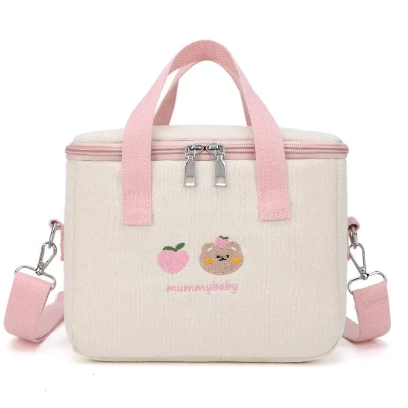White insulated kawaii lunch bag with pink straps and embroidered designs on a white background