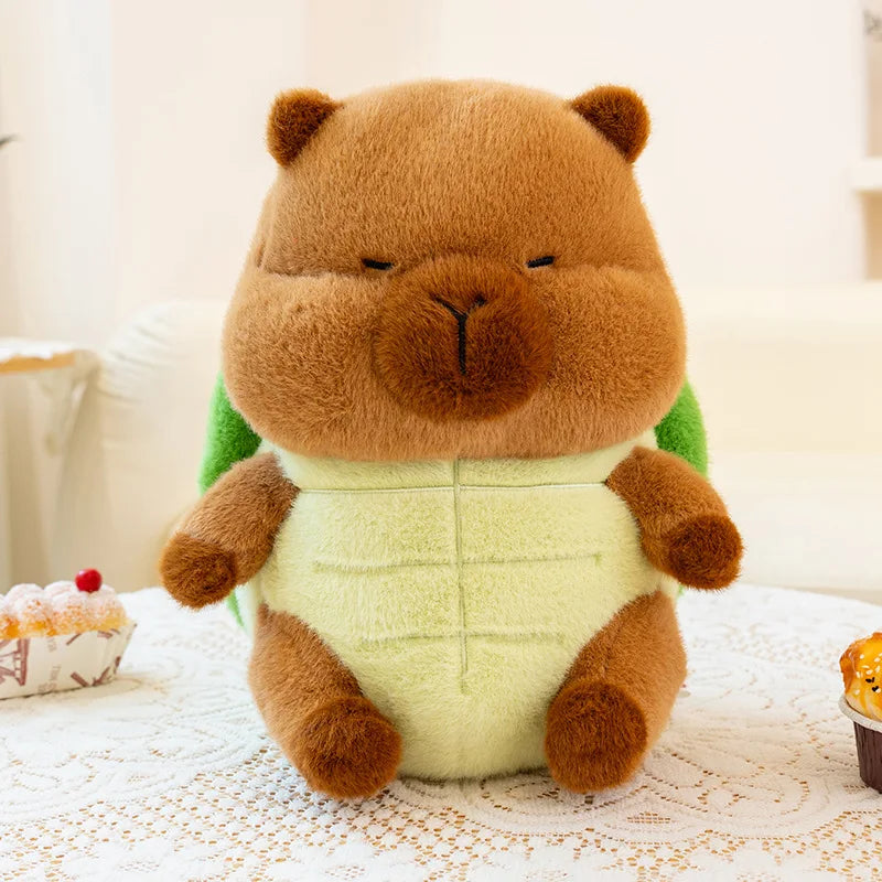 Kawaii plush toy resembling a bear in a green shirt on a lace tablecloth with cupcakes in the background.