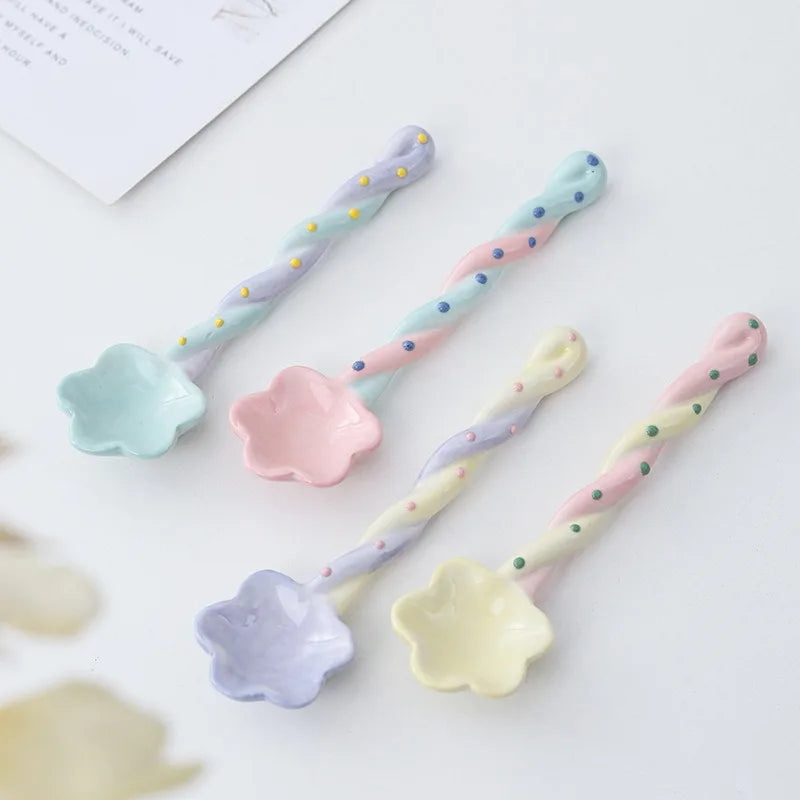 A set of four rainbow ceramic kawaii spoons on a table