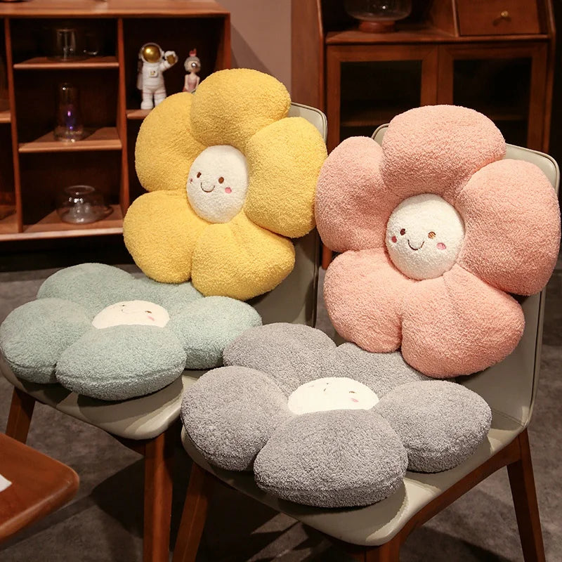Flower-shaped kawaii cushions in yellow, pink, and gray on a chair with a wooden shelf in the background.