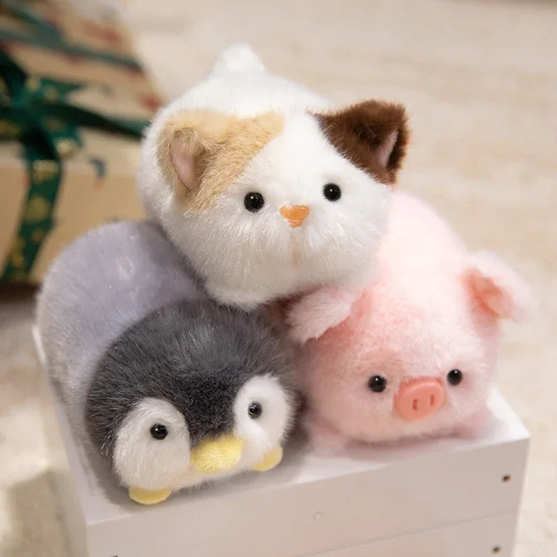 Three small kawaii plush toys shaped like a cat, penguin, and pig on a white box.