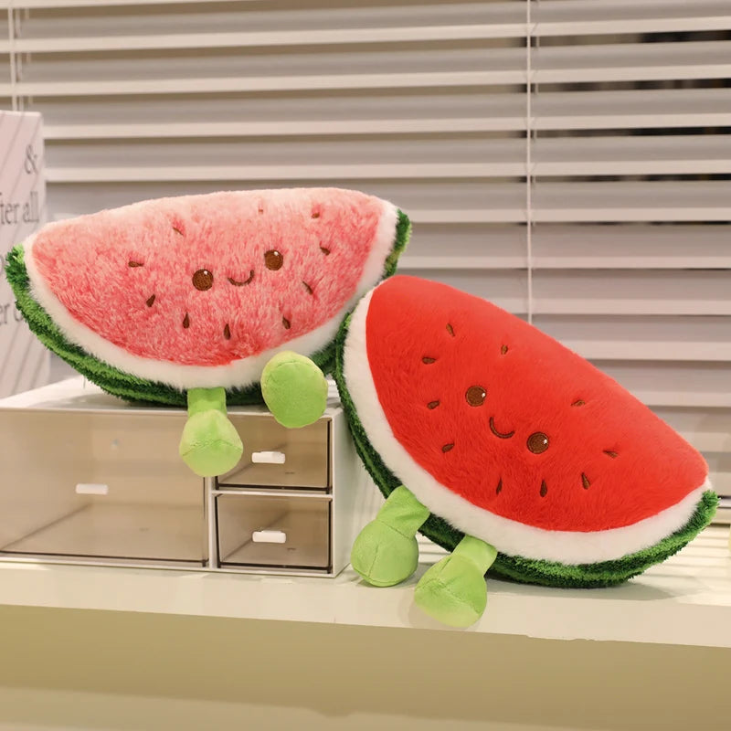 Two kawaii plush watermelon toys on a surface with a window blind background