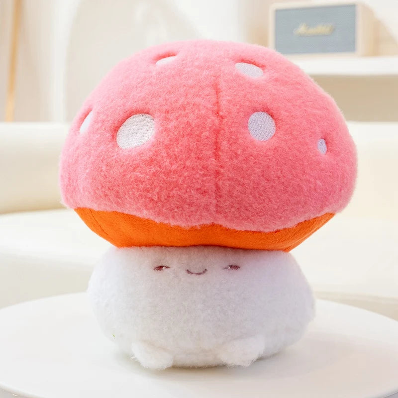 Kawaii plush toy shaped like a pink mushroom with an orange stem on a white surface.