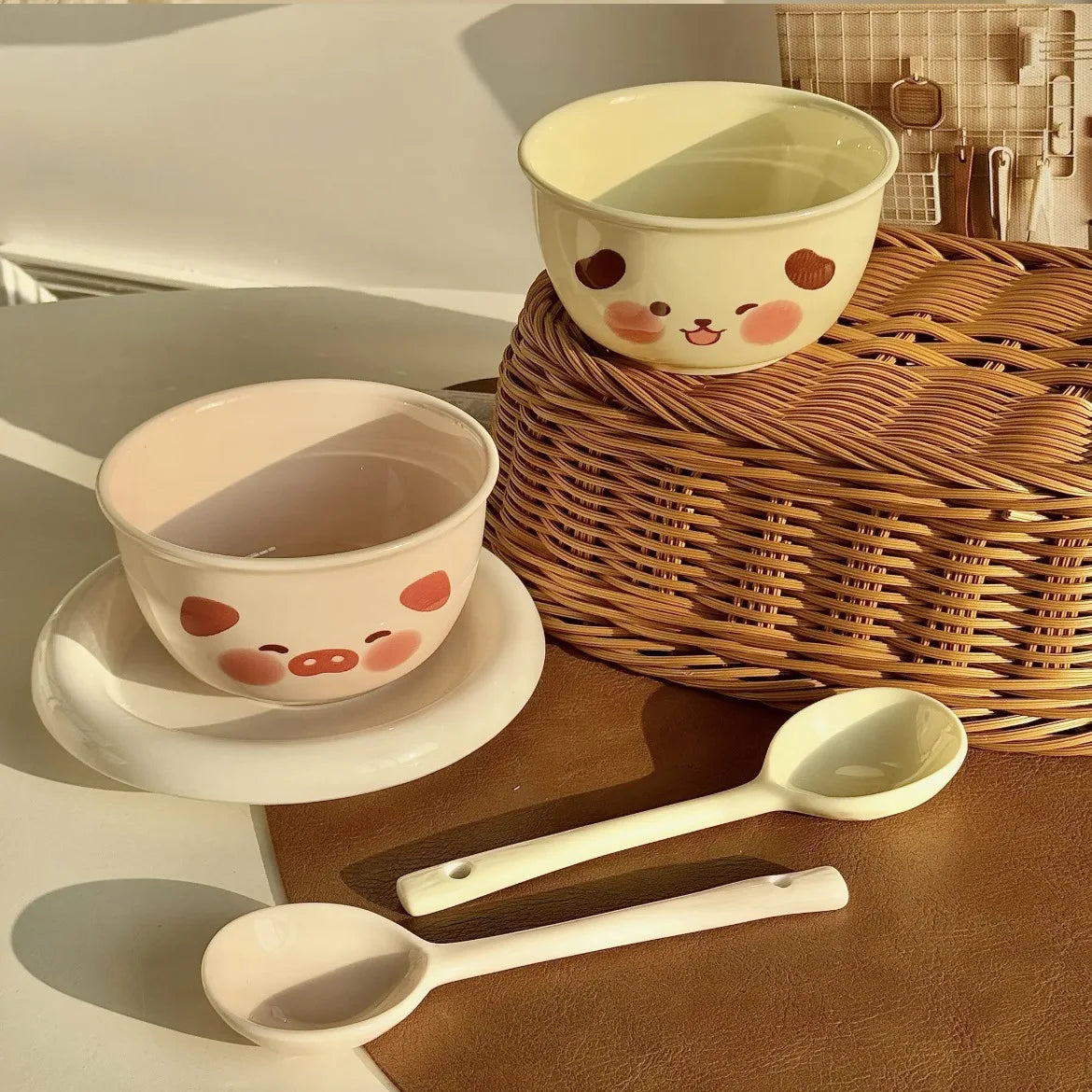 Ceramic kawaii ramen bowls and spoons with cartoon faces on a wooden surface
