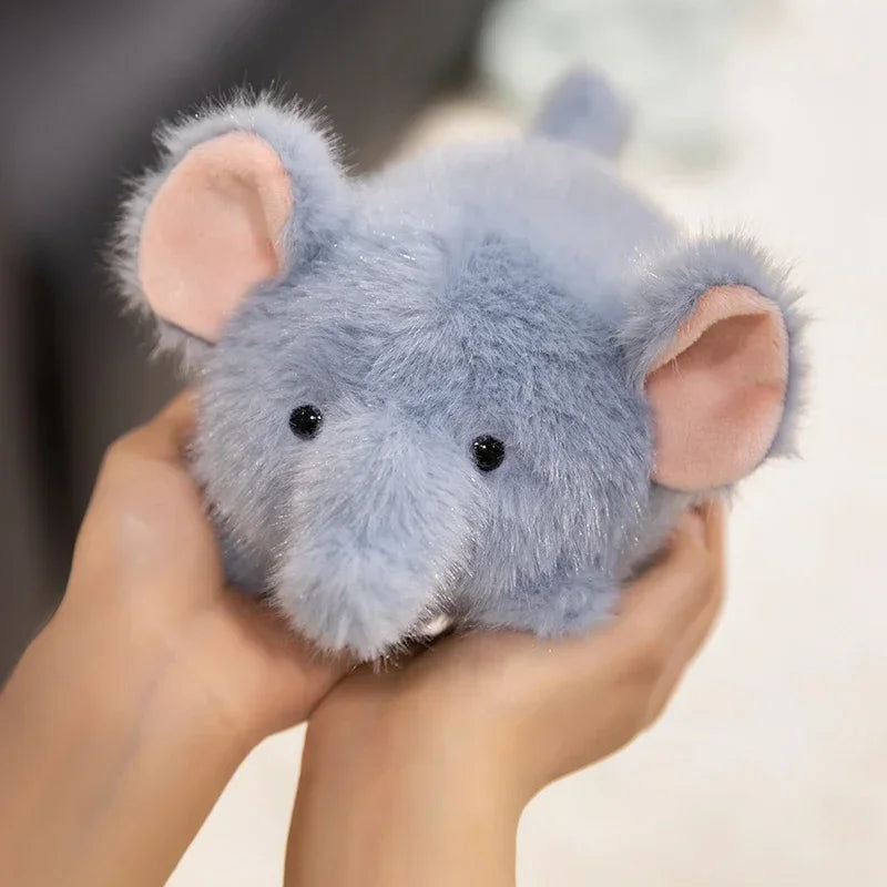 Kawaii plush toy mouse held in hands with a blurred background