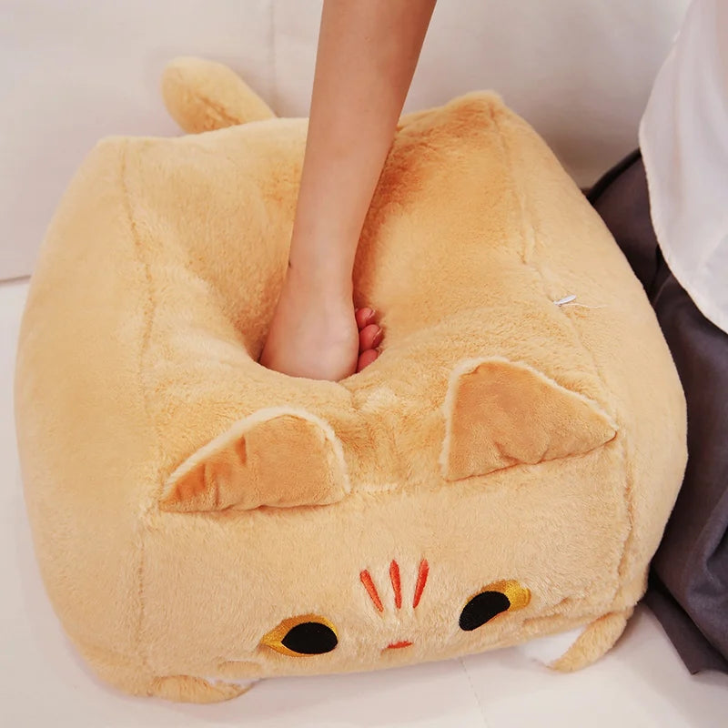 Cat-shaped kawaii plush pillow with a person's foot inside, on a light background