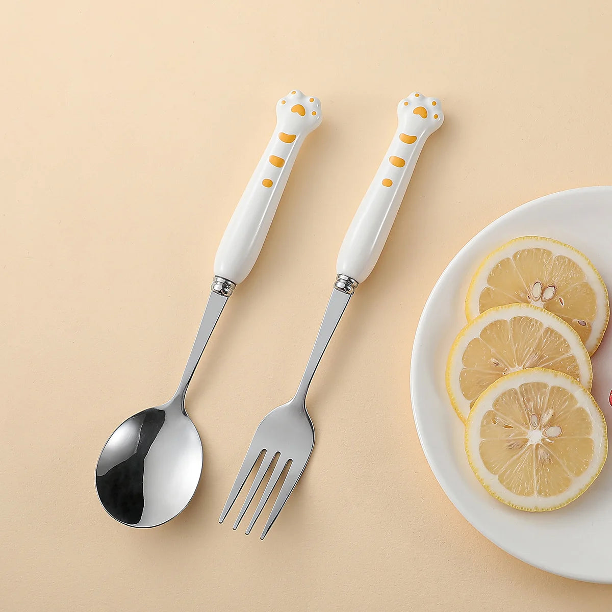 A set of white, paw shaped kawaii utensils on a yellow background