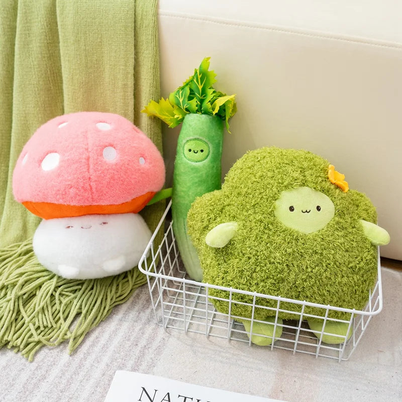 Kawaii plush toys shaped like a mushroom, celery, and broccoli on a couch with a green blanket.