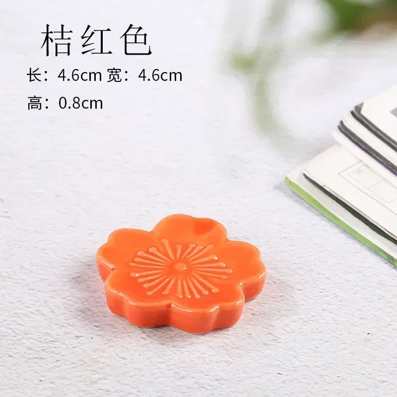 Orange flower-shaped kawaii chopstick holder on a white surface with text providing dimensions.