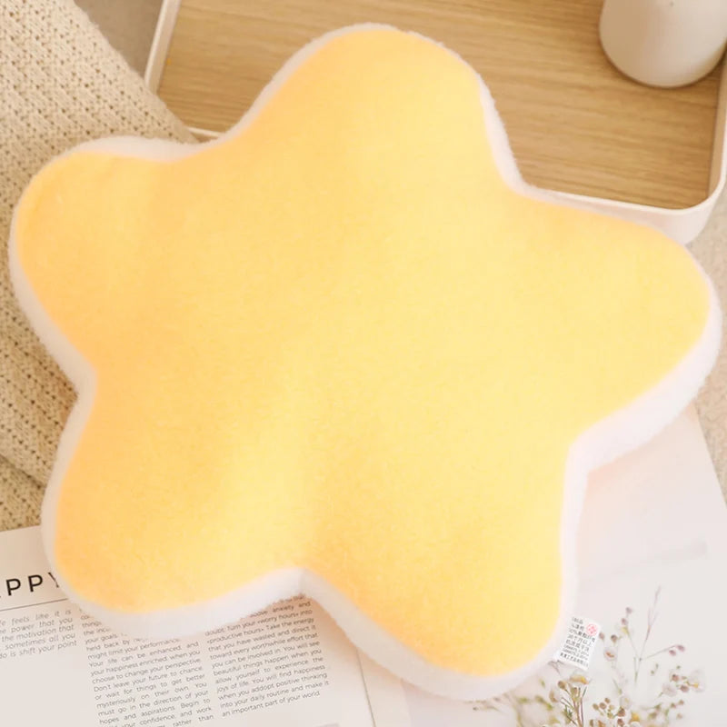 Yellow star-shaped kawaii cushion on a surface with text and objects in the background