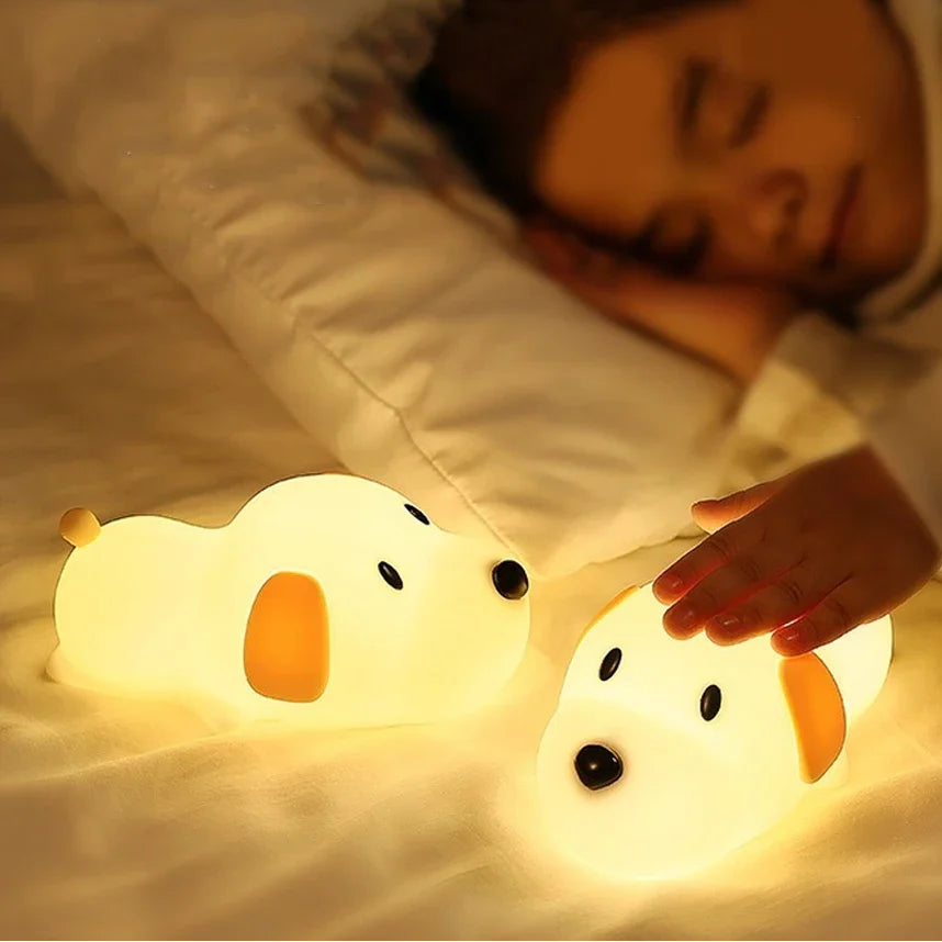 Two cartoon duck kawaii night lights on a bed with a person lying in the background.