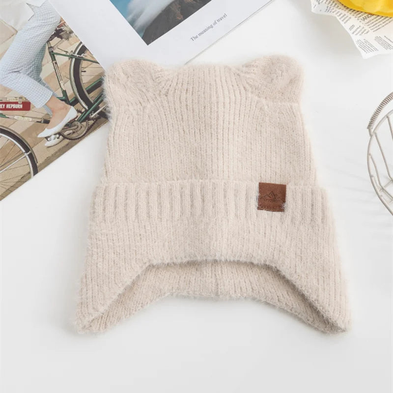 Beige knitted Kawaii pillow with a brand label on a white surface