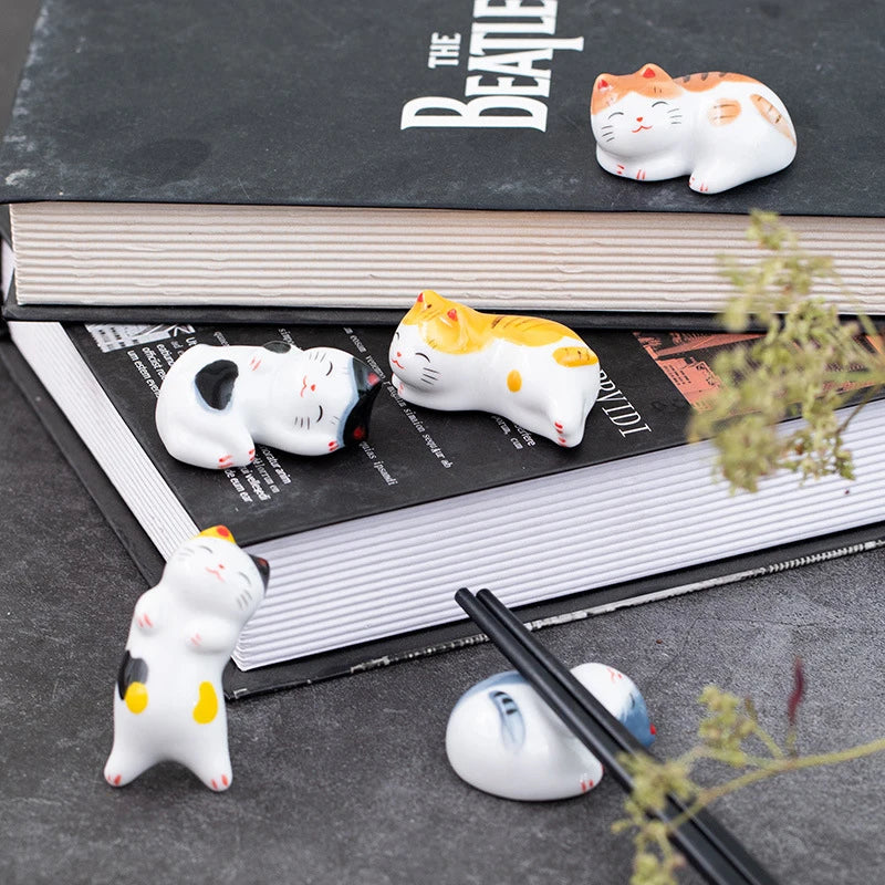 Kawaii cat-shaped ceramic chopstick rest on a book with 'The Beatles' album cover.