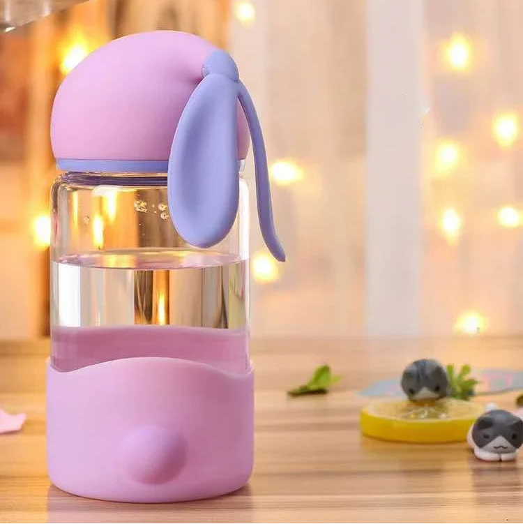 Pink and purple kawaii tumbler with a handle on a wooden surface.
