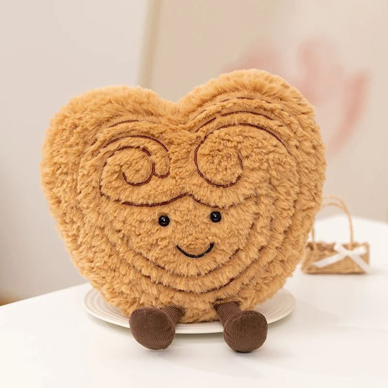 Heart-shaped kawaii plush toy with a smiling face and glasses on a white surface.