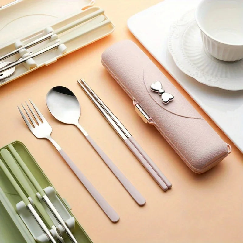 Set of silver kawaii utensils with a pink case on a peach-colored surface.