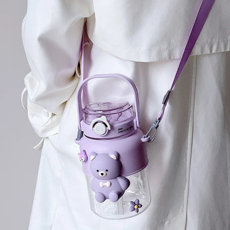 Purple kawaii water bottle with bear design and strap on a white background