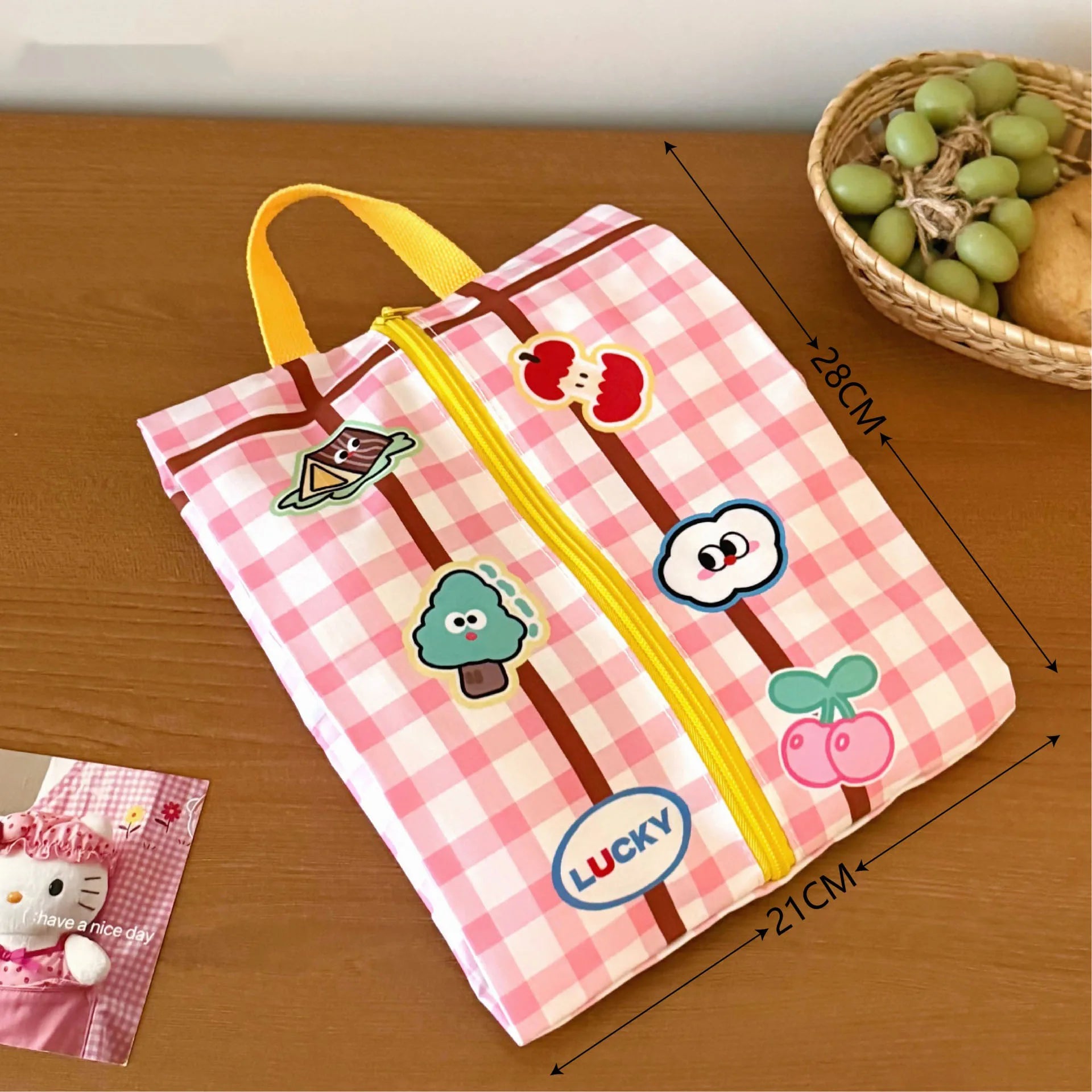 Pink checkered bag with Kawaii cartoon characters on a wooden surface