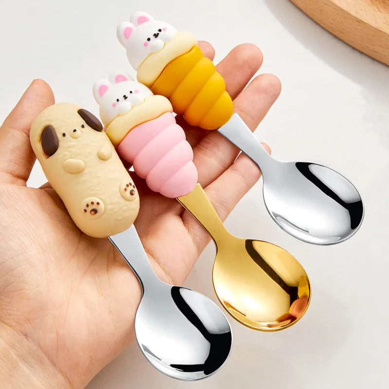 Three cartoon-themed kawaii utensils held by a hand on a light background