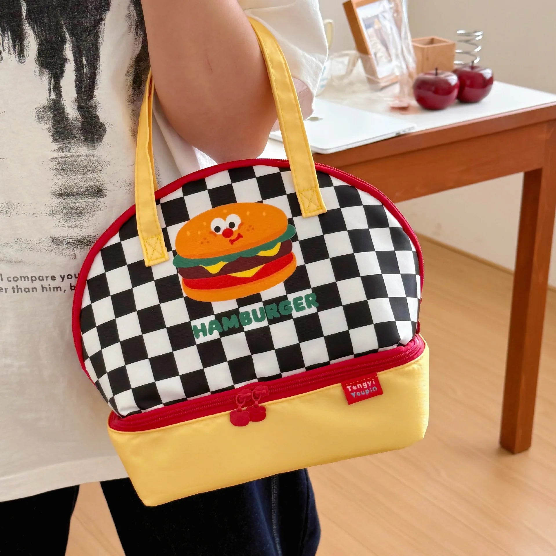 Checkered kawaii bag with a hamburger design held by a person indoors.