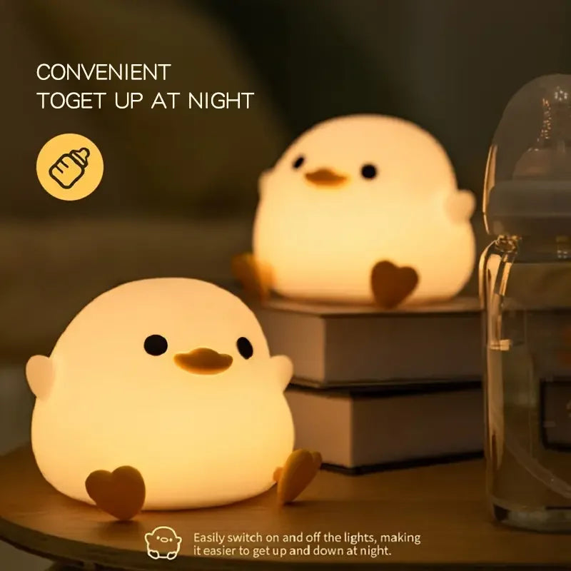 Two cute chick-shaped kawaii night lights on a table with a dark background.
