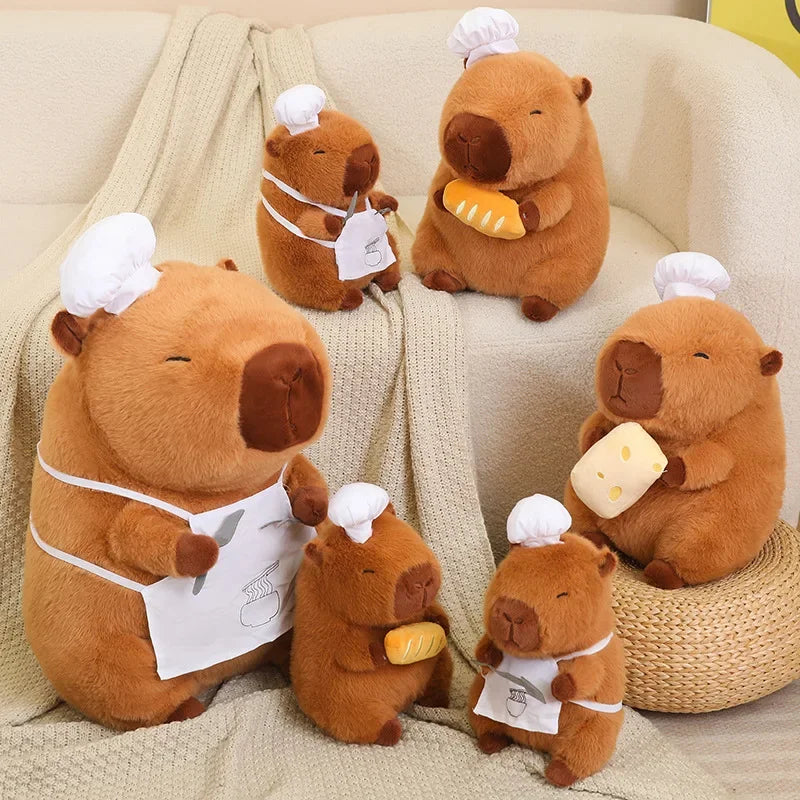 Set of kawaii plush beaver toys in chef attire on a couch with a blanket.