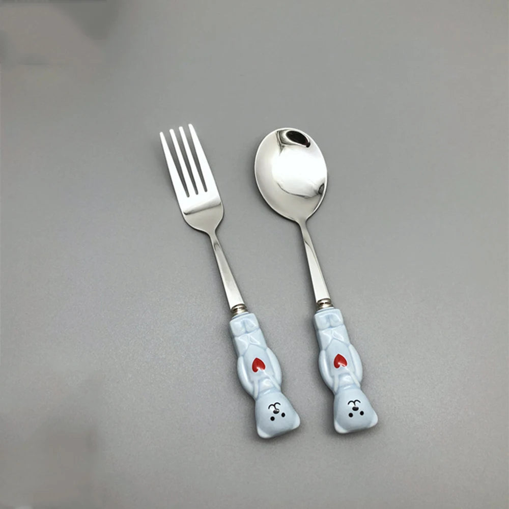 Blue, bear shaped kawaii utensils on a gray background
