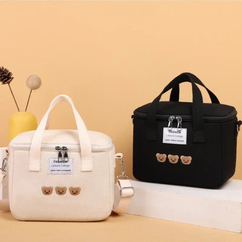 Two kawaii lunch bags, one beige and one black, with bear decorations on a beige background.