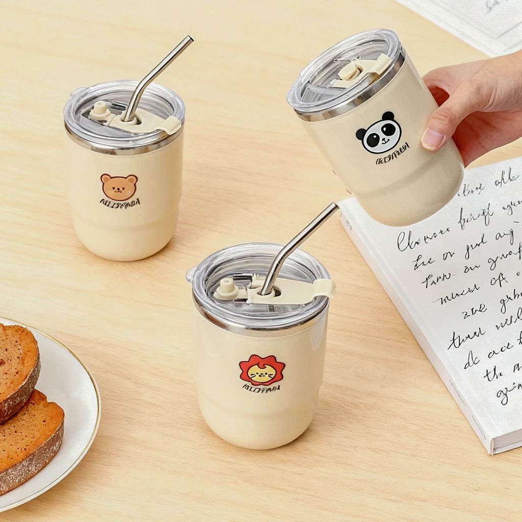 Three insulated kawaii cups with animal-themed designs on a wooden table.