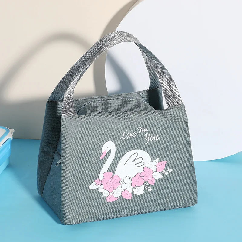 Gray kawaii lunch bag with a swan design and 'Love For You' text on a blue surface.