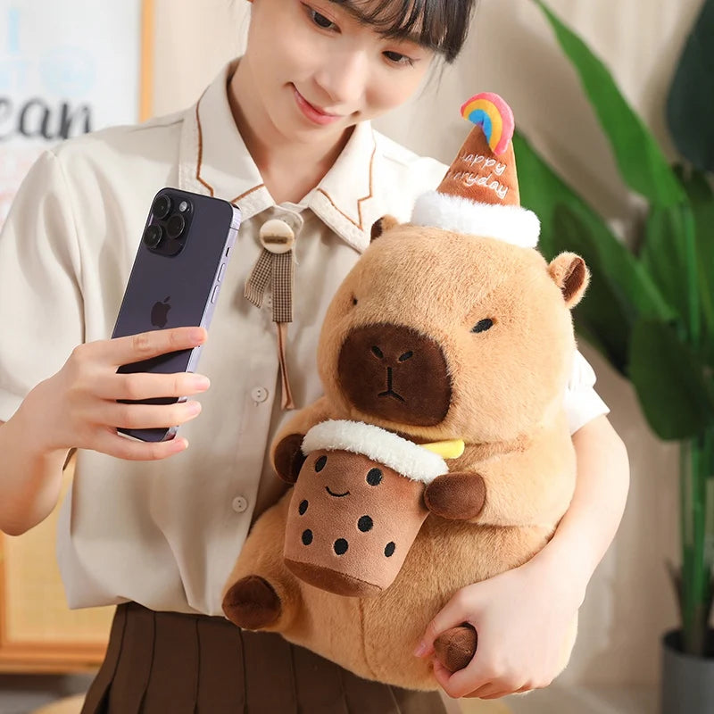 Person holding a capybara plush toys and taking a selfie with a phone