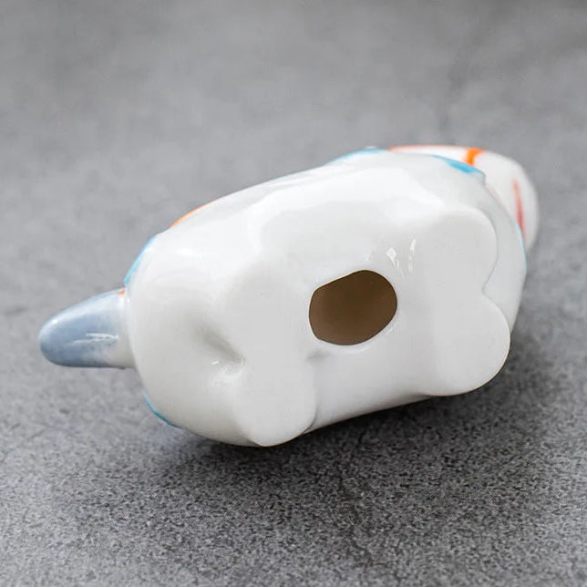 White ceramic kawaii chopstick holders with a hole on a gray surface