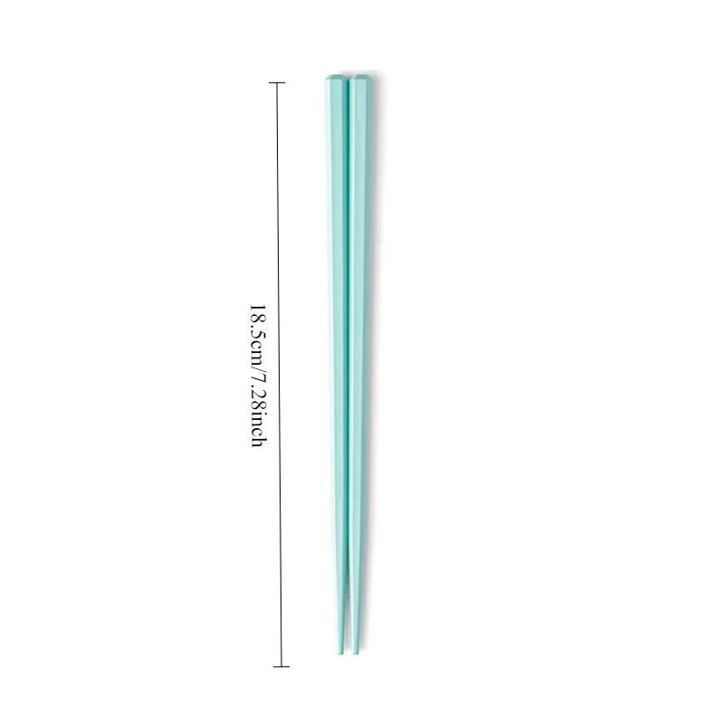 Two green kawaii chopsticks with measurements on a white background