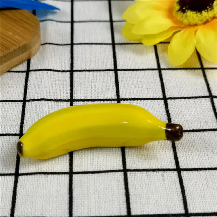Yellow ceramic banana kawaii chopstick holders on a checkered fabric background