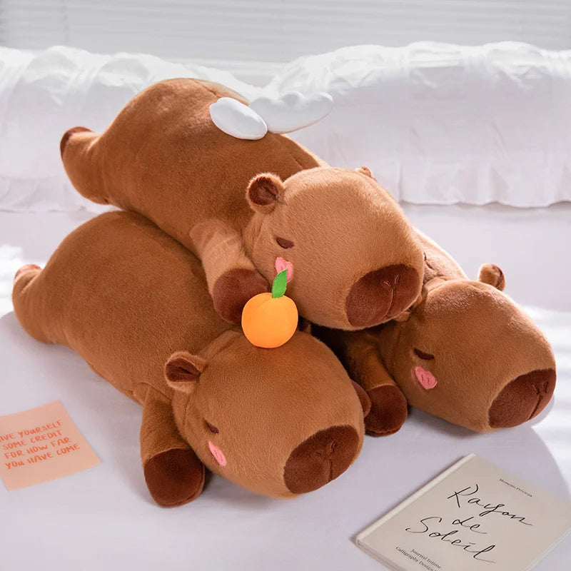 Stack of brown kawaii plush toys resembling animals on a white surface with a card and small orange object.