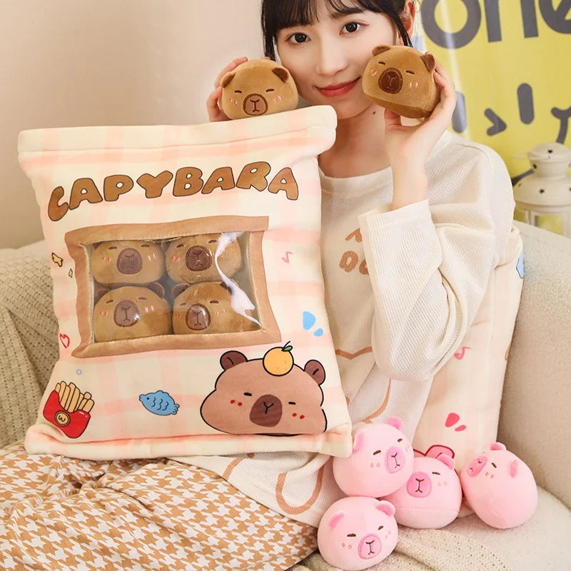 Person holding a capybara kawaii plush toy and pillow with cartoon bear design.
