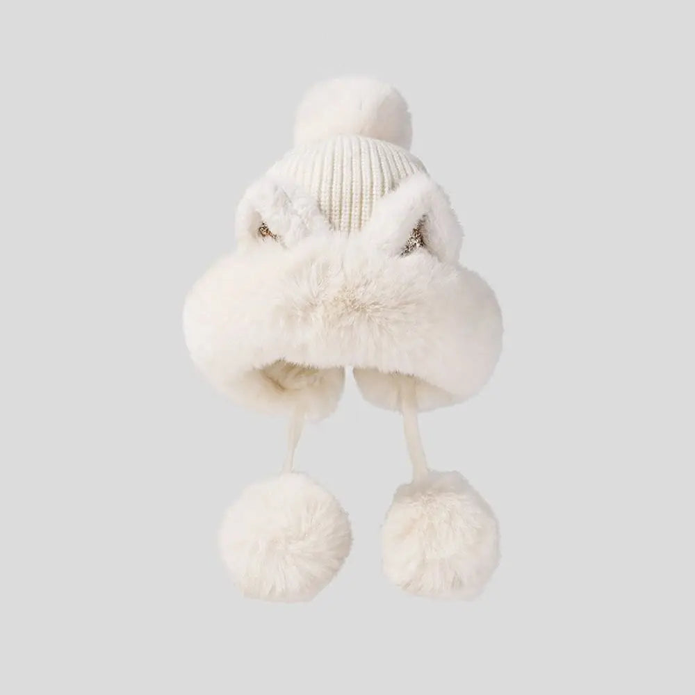 White knitted Kawaii hat with pom-poms on a light gray background